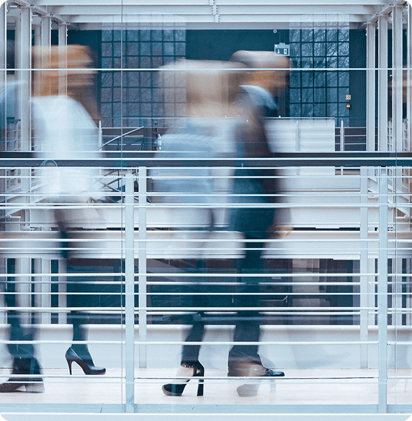 Modern business professionals walking in a corporate office building.