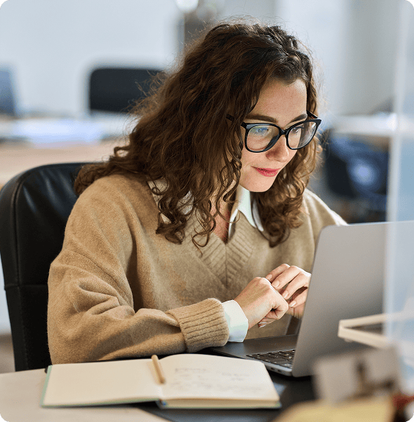Efficient woman working on a laptop in an office environment, focusing on digital integration and pr.